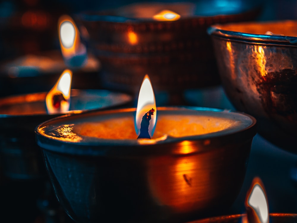 lighted candle in brown ceramic bowl