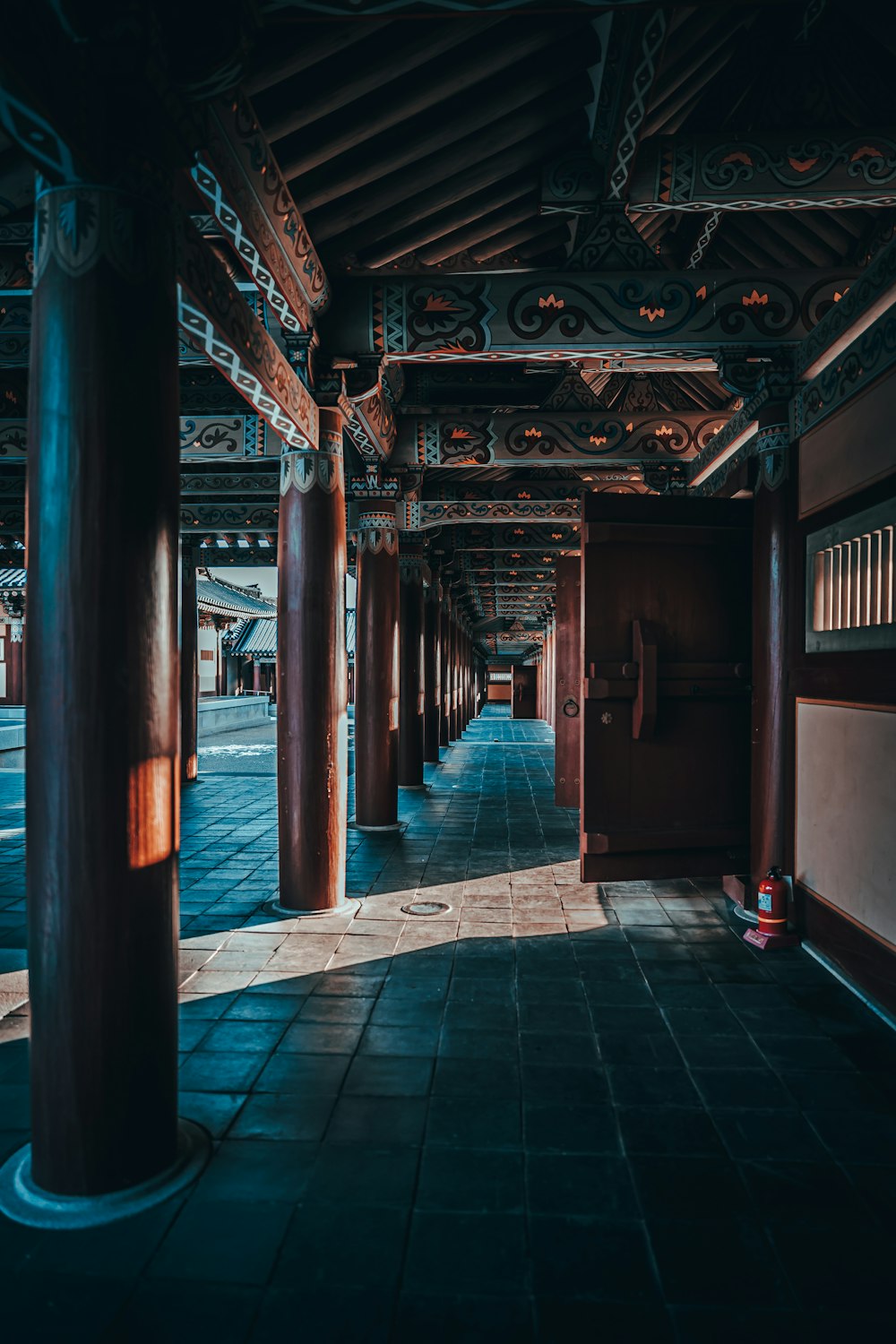 青いタイル張りの床に茶色の木製の廊下