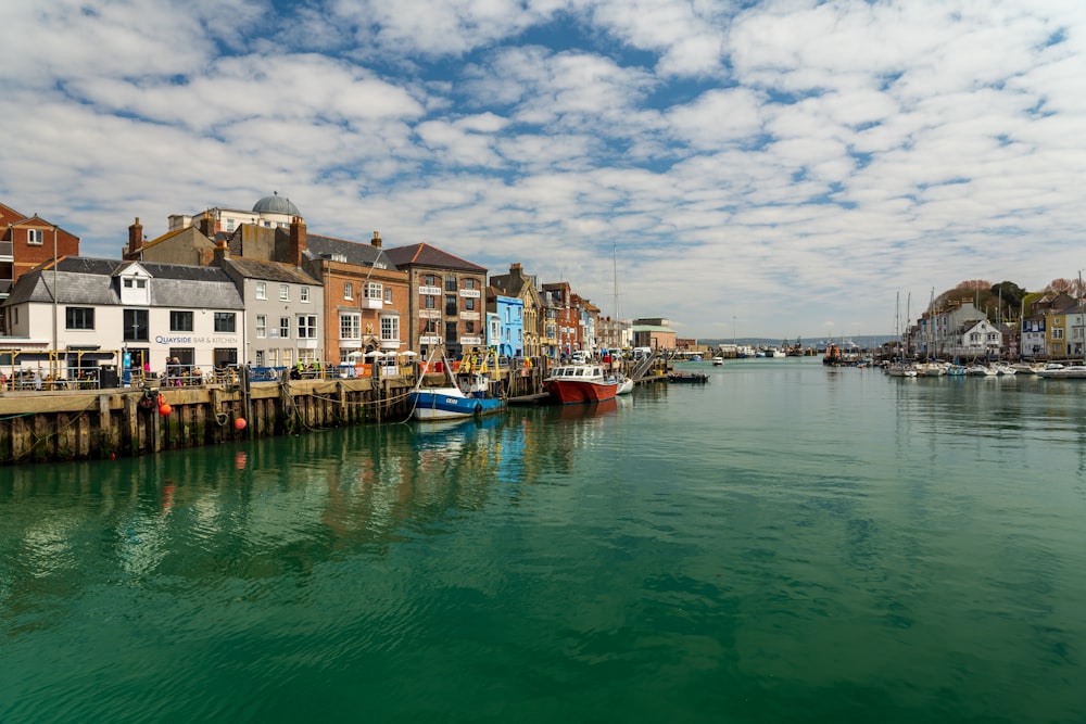 boat on water near houses under cloudy sky during daytime