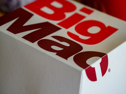 A close-up of a Big Mac packaging box with bold red and white lettering, showcasing part of the logo and design.