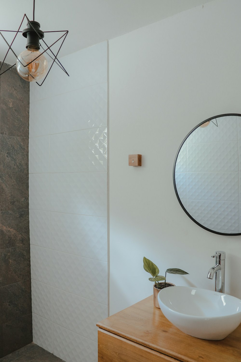 white ceramic sink near round mirror