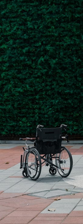 black bicycle parked beside green wall