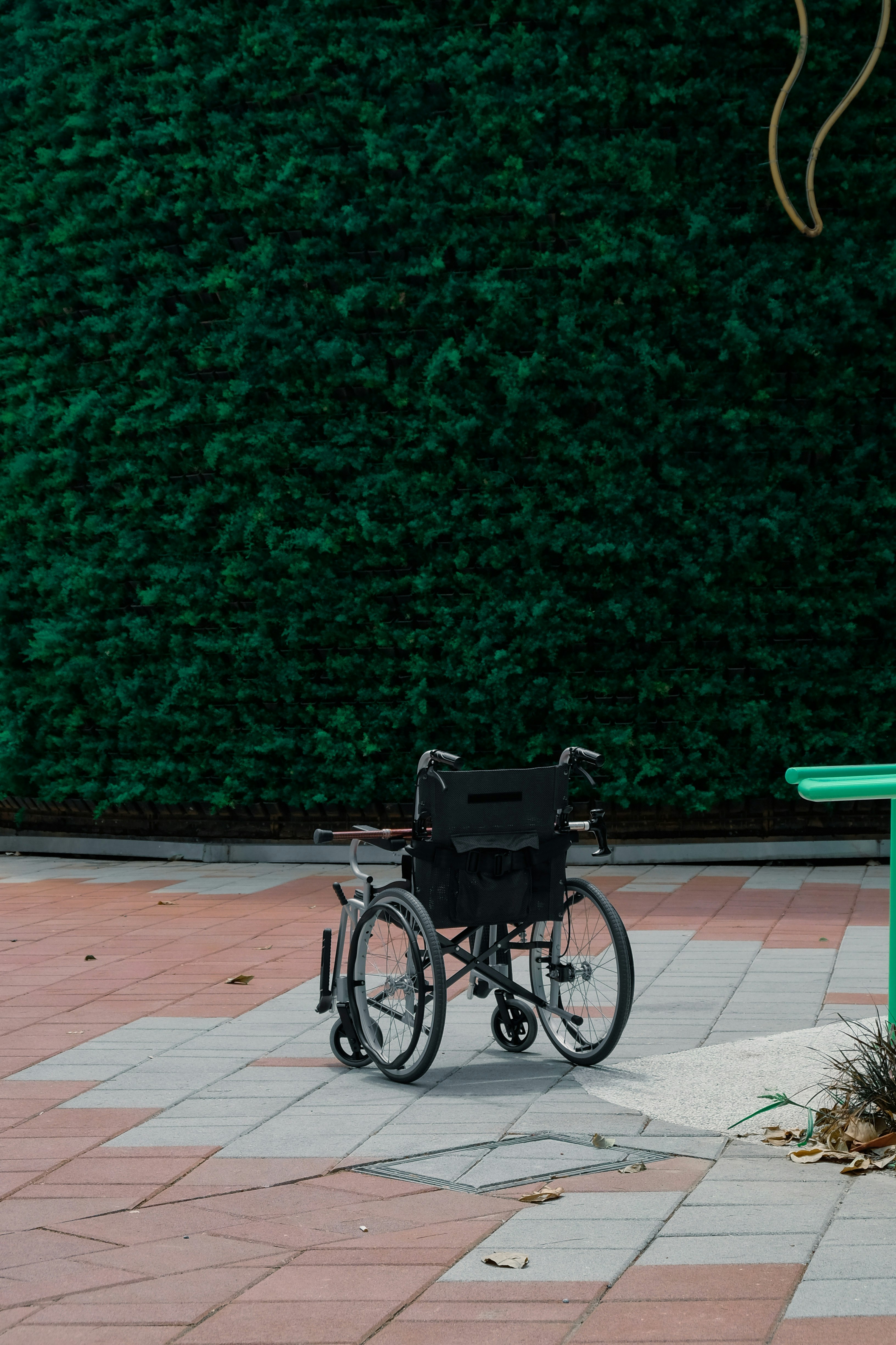 black bicycle parked beside green wall