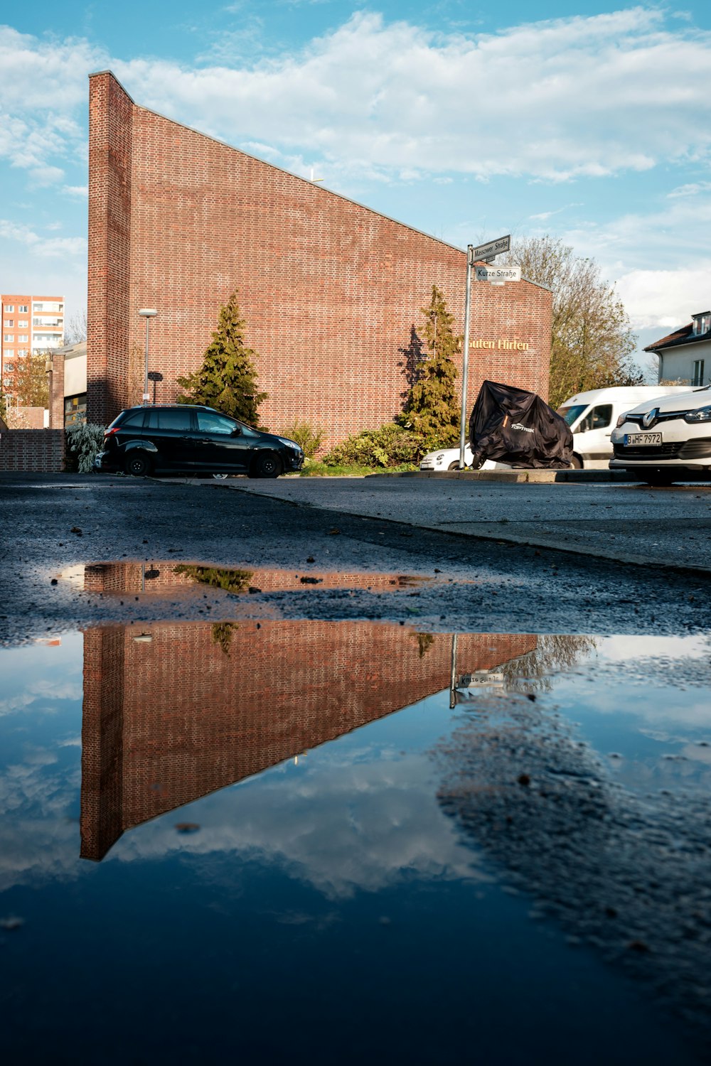 Autos, die tagsüber neben einem braunen Backsteingebäude geparkt werden