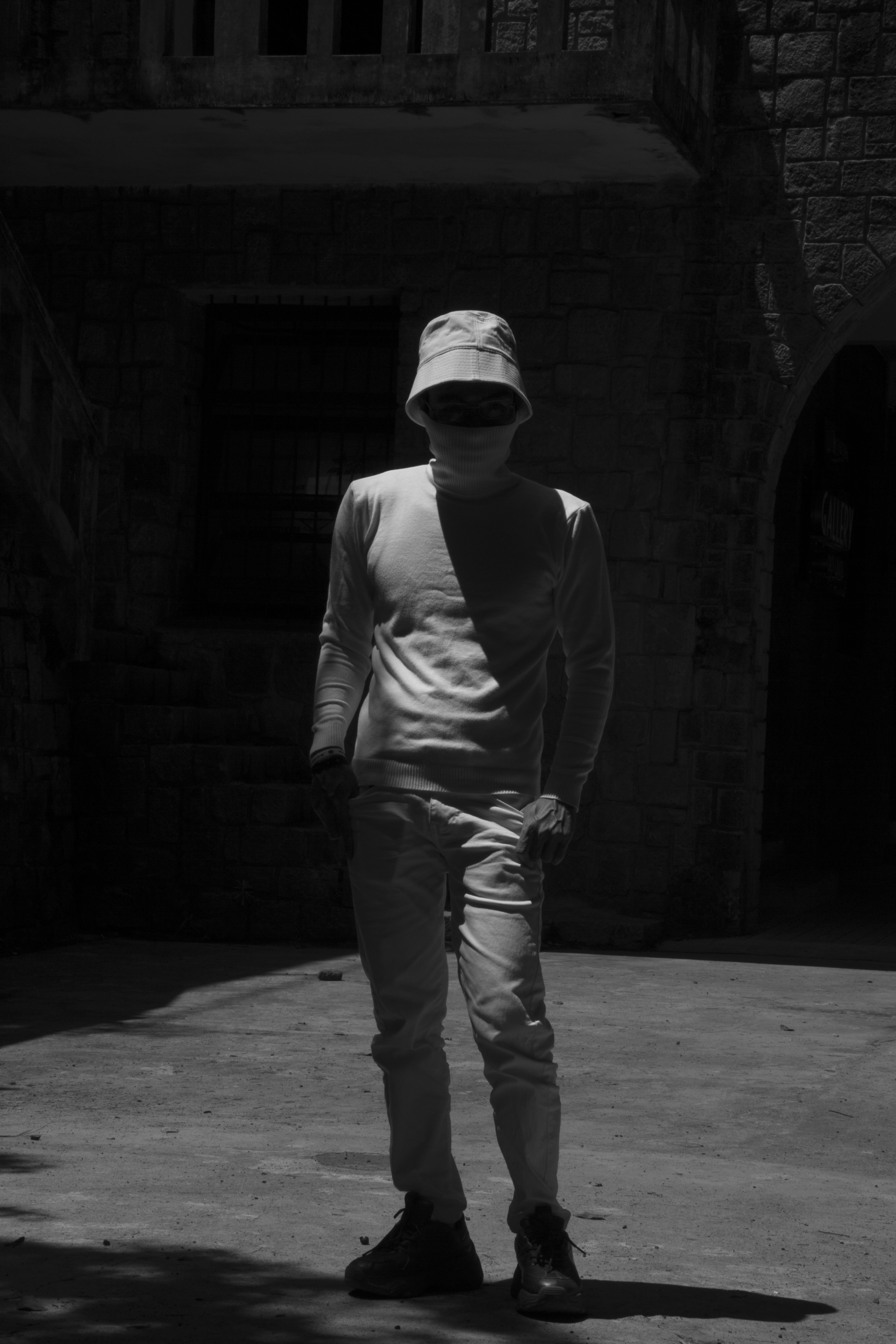 man in gray long sleeve shirt and pants standing on gray concrete floor