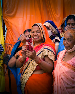 A collage of diverse Maheshwari individuals smiling and engaging with their profiles on a digital device.
