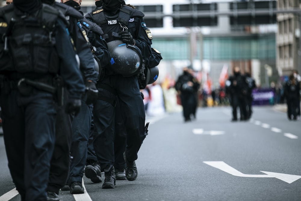 homme en veste de cuir noir marchant sur la route pendant la journée