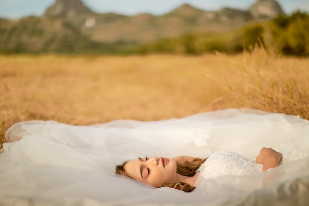 woman lying on white textile
