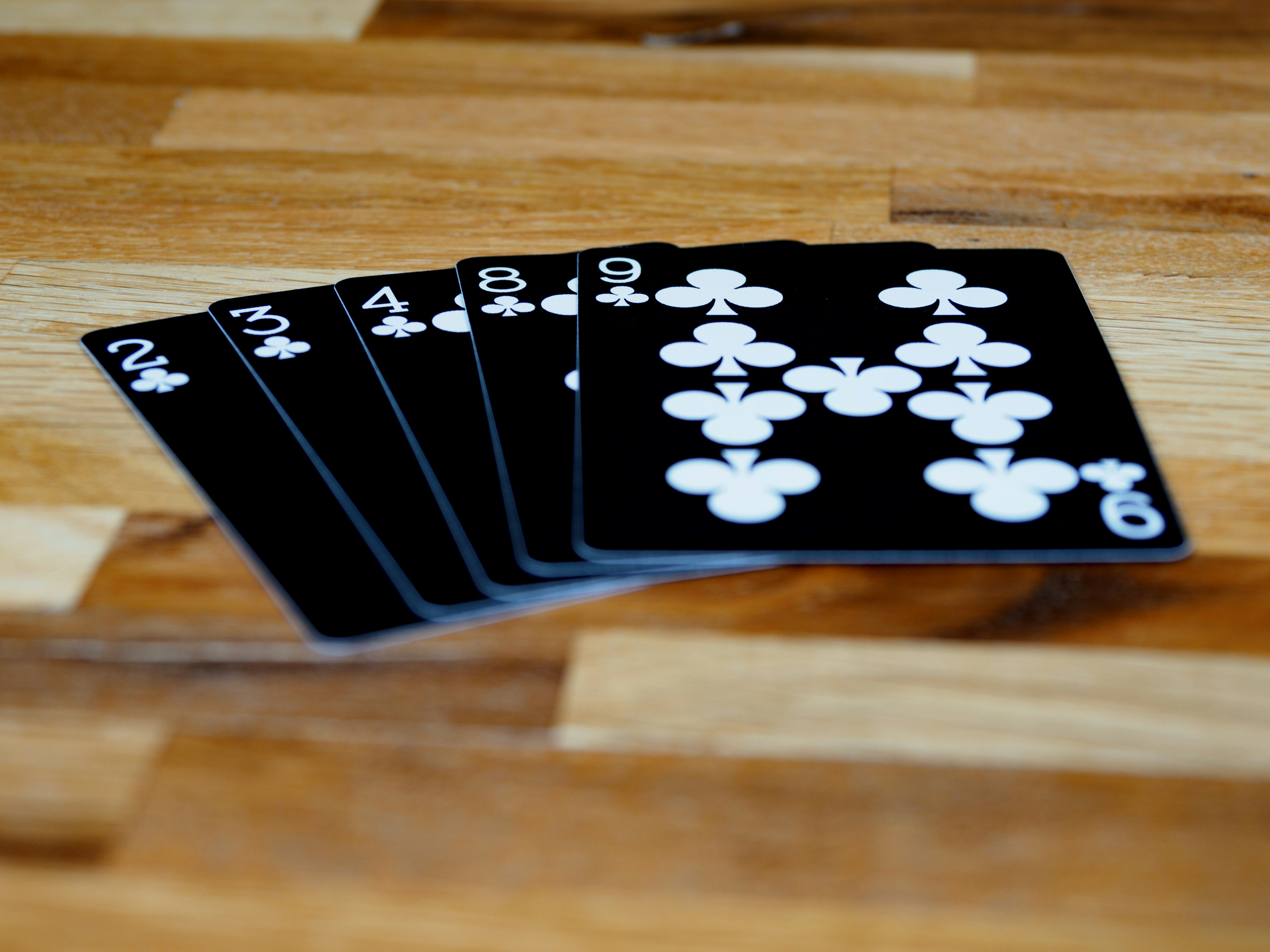 cards, playing cards, gambling, close up, bokeh, wood background, product shot, focus, deal, bad hand, worst poker hand, poker, throw away, fold, lose, losing hand,