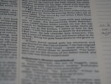 A close-up view of a page from a book or document, featuring printed English text with a portion of handwritten notes in the margins. The text appears to be formatted in paragraphs with some bolded headings.