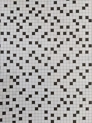 A grid of black and white squares creates a checkerboard pattern. The squares are arranged in a random order, interspersing black squares with white ones across the grid, creating a visually dynamic and recurring pattern.