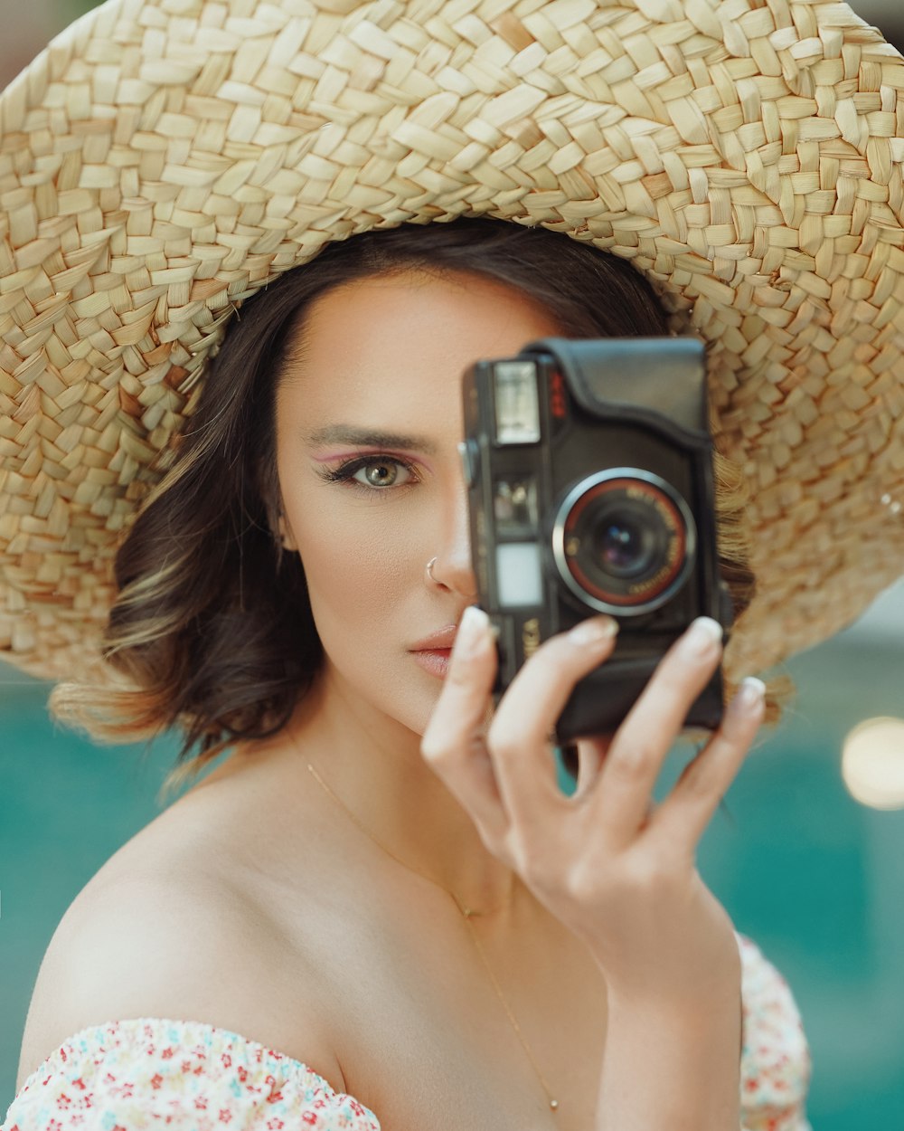 woman in brown sun hat holding black camera