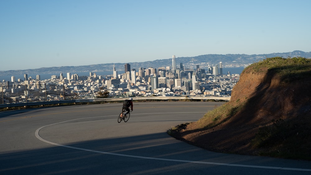 man in black shirt riding bicycle on road during daytime