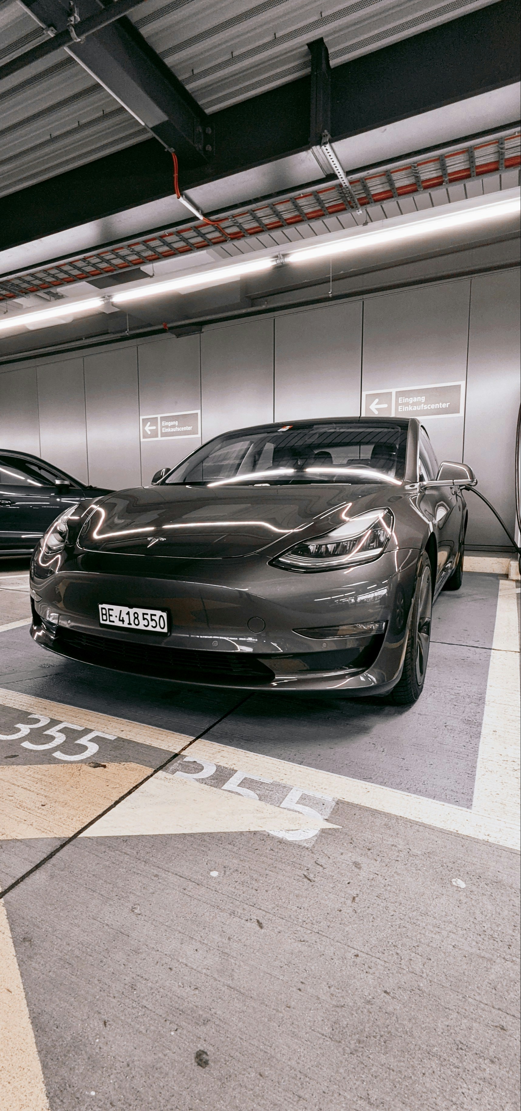 Electric vehicle plugged into home Level 2 charger in garage, modern home setting