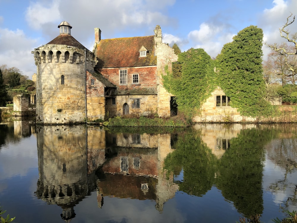 edificio in cemento marrone vicino allo specchio d'acqua durante il giorno