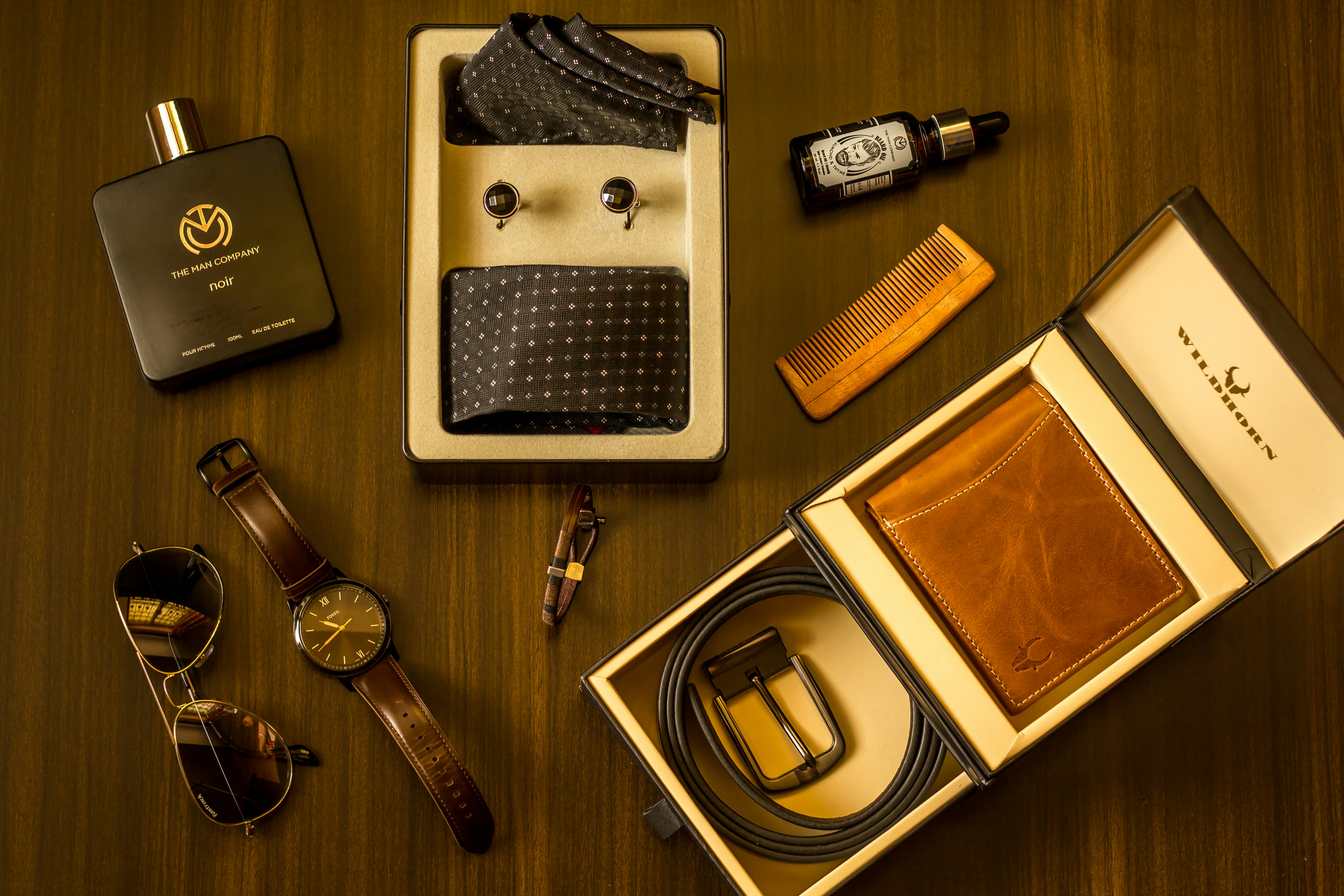 Premium mens gift set with watch wallet grooming kit on dark wooden surface moody lighting