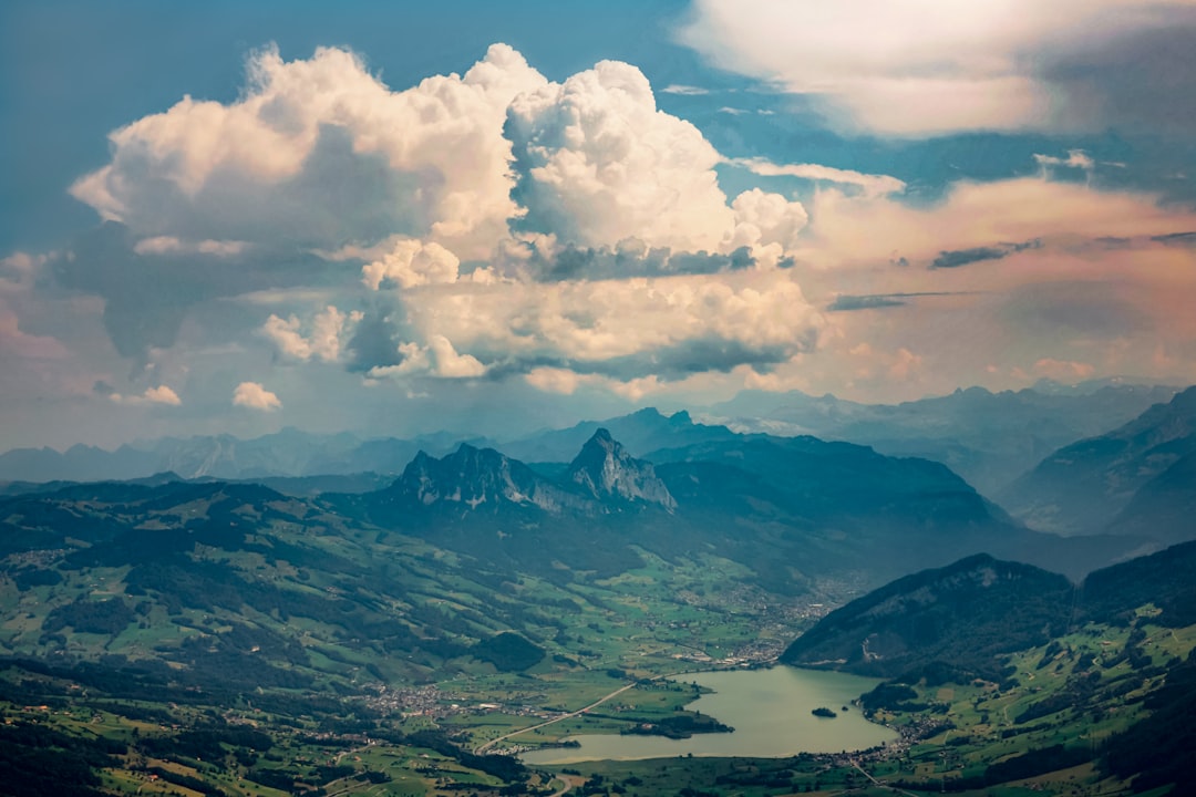 white clouds over mountains and lake