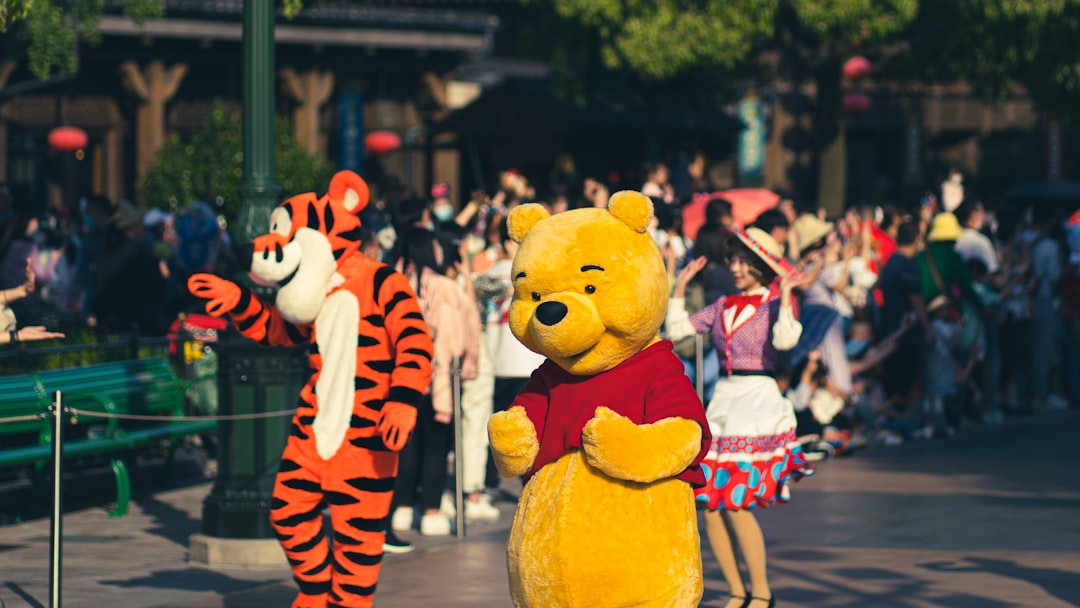 people standing near yellow bear statue during daytime