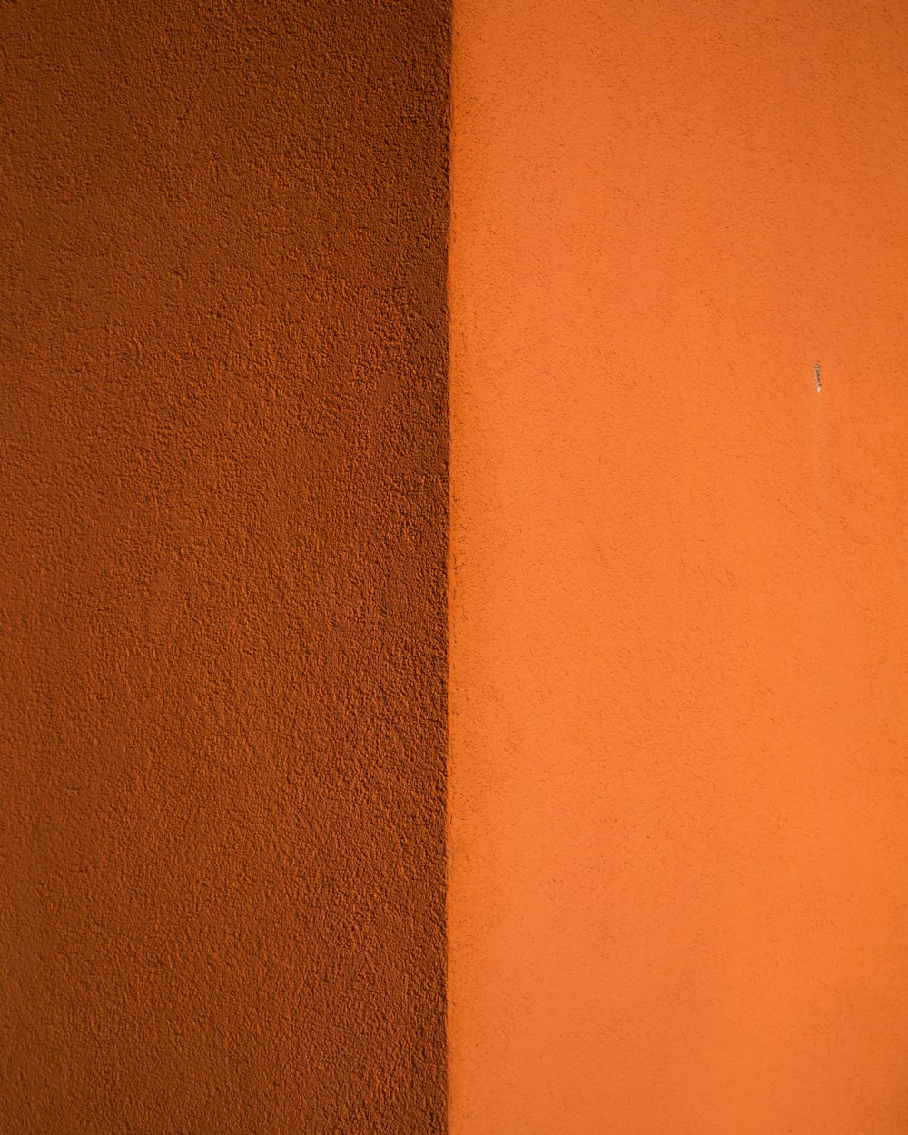 茶色の木製テーブルの近くのオレンジ色の壁のペンキ