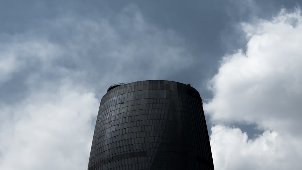 a tall black building with a sky background