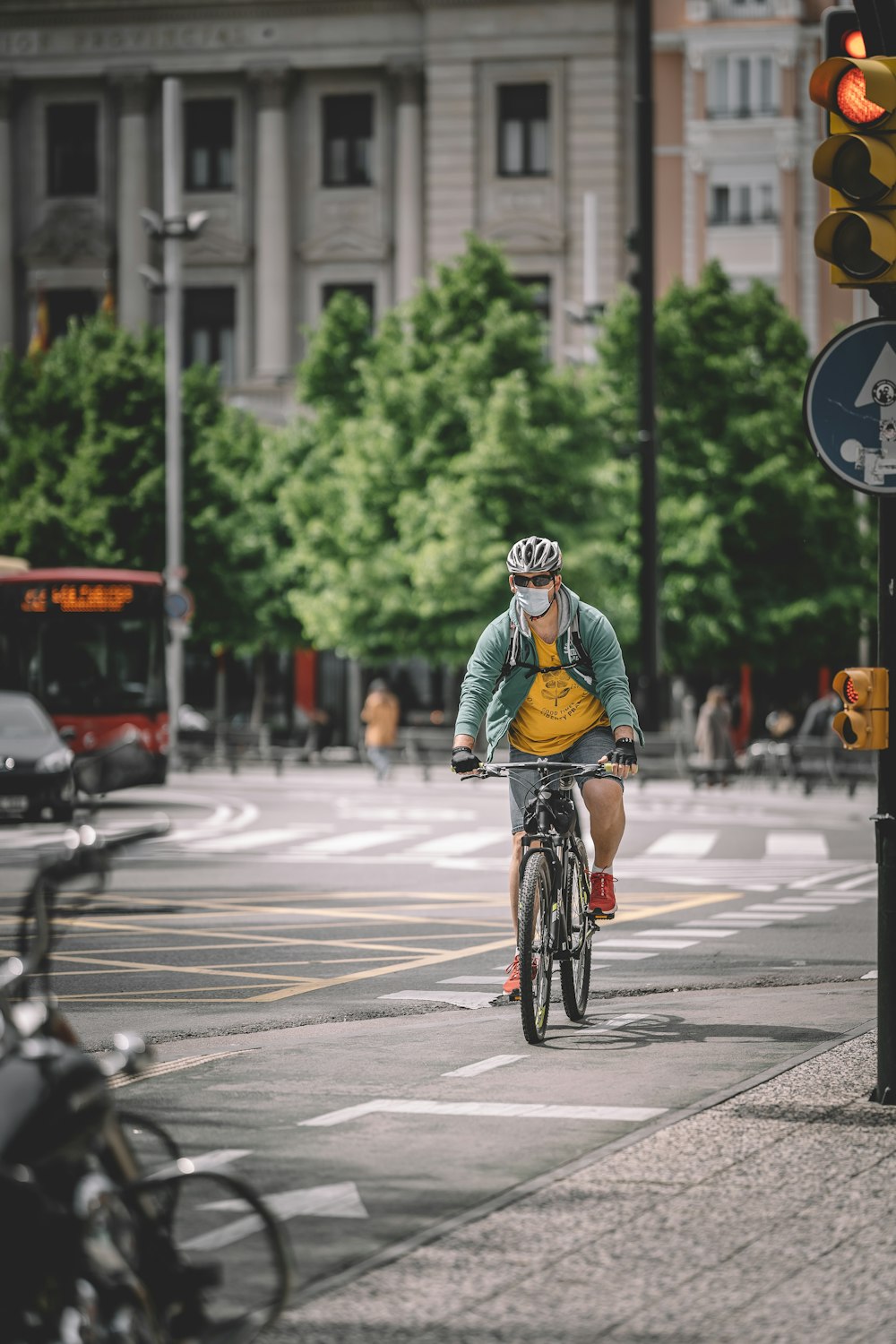 man in green shirt riding bicycle on road during daytime