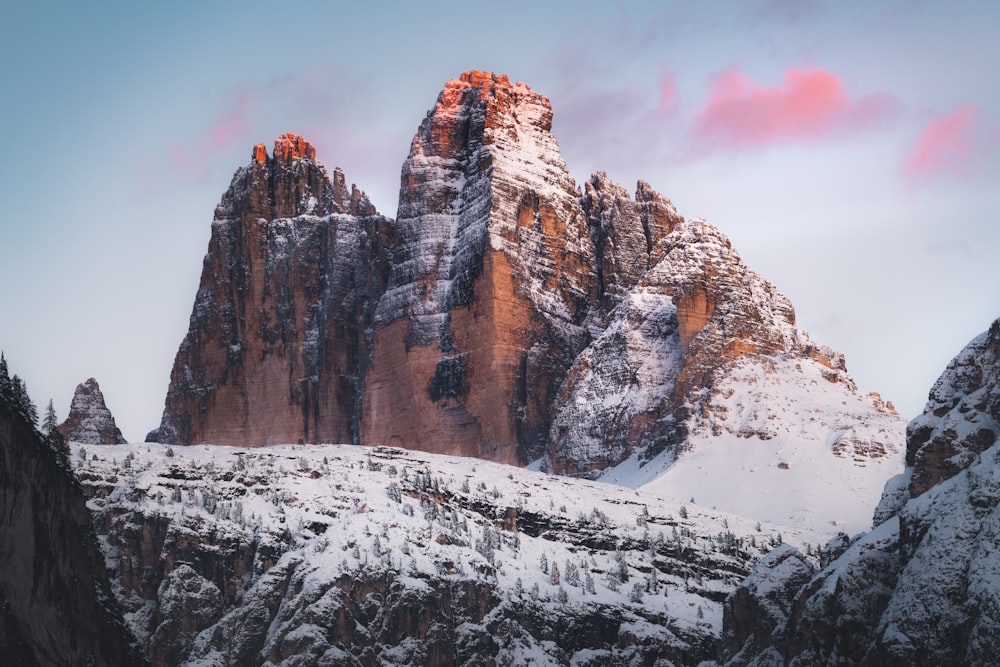 brown rocky mountain covered by snow during daytime