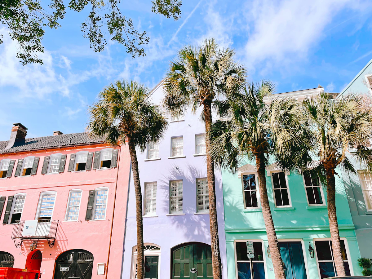 Pastel Rainbow Row houses behind palms