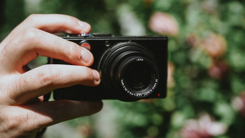 person holding black camera lens