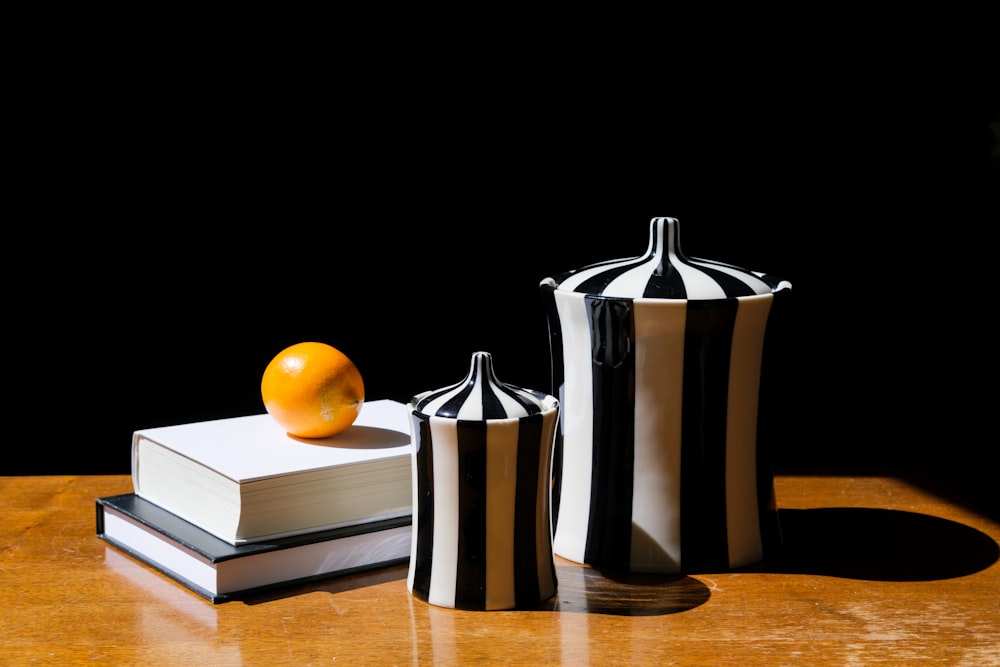 2 orange fruits beside stainless steel pitcher