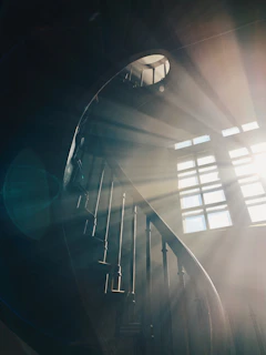 A tranquil scene of a sunlit spiral staircase blending with natural textures and warm light.