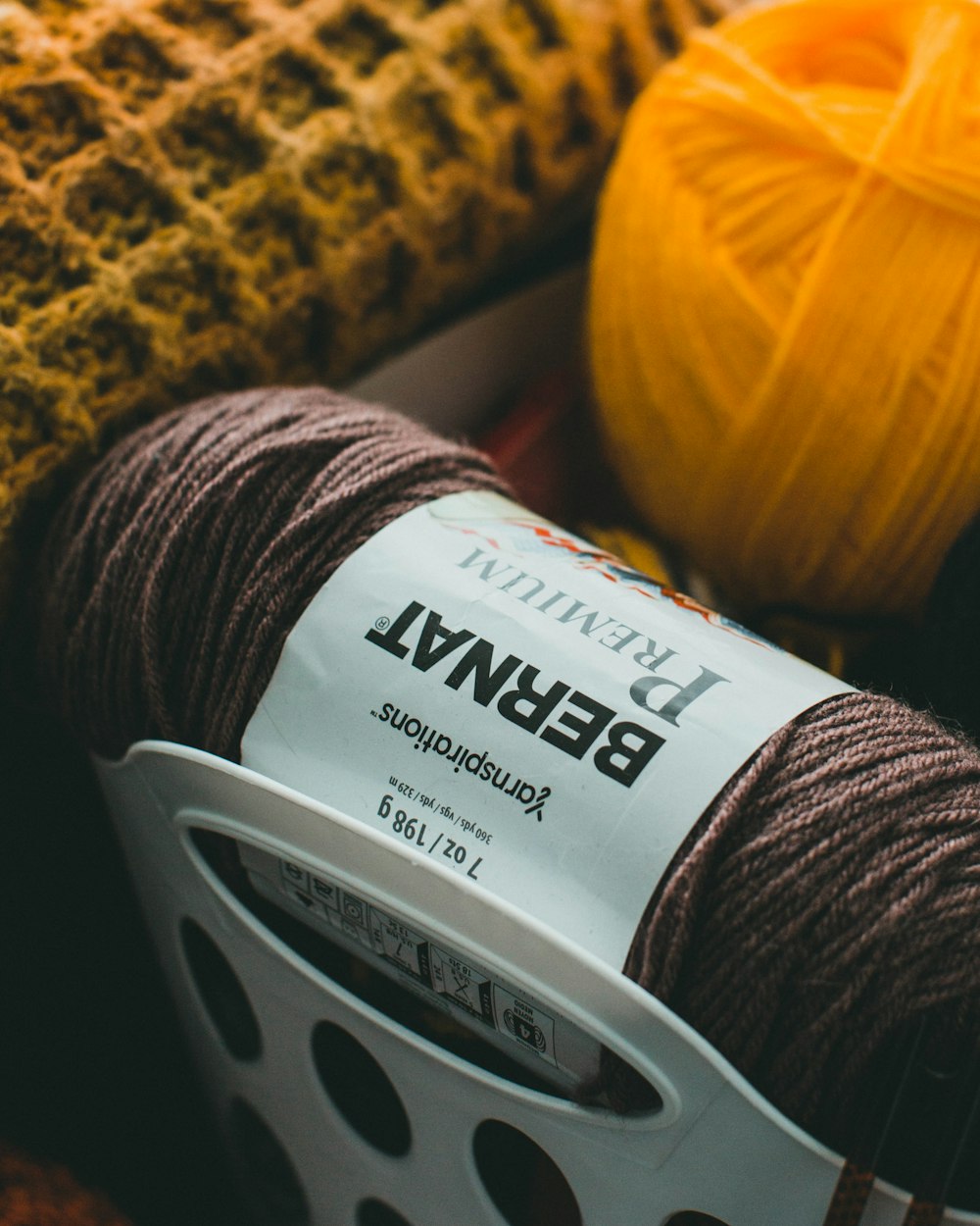 yellow and red yarn on brown and black textile