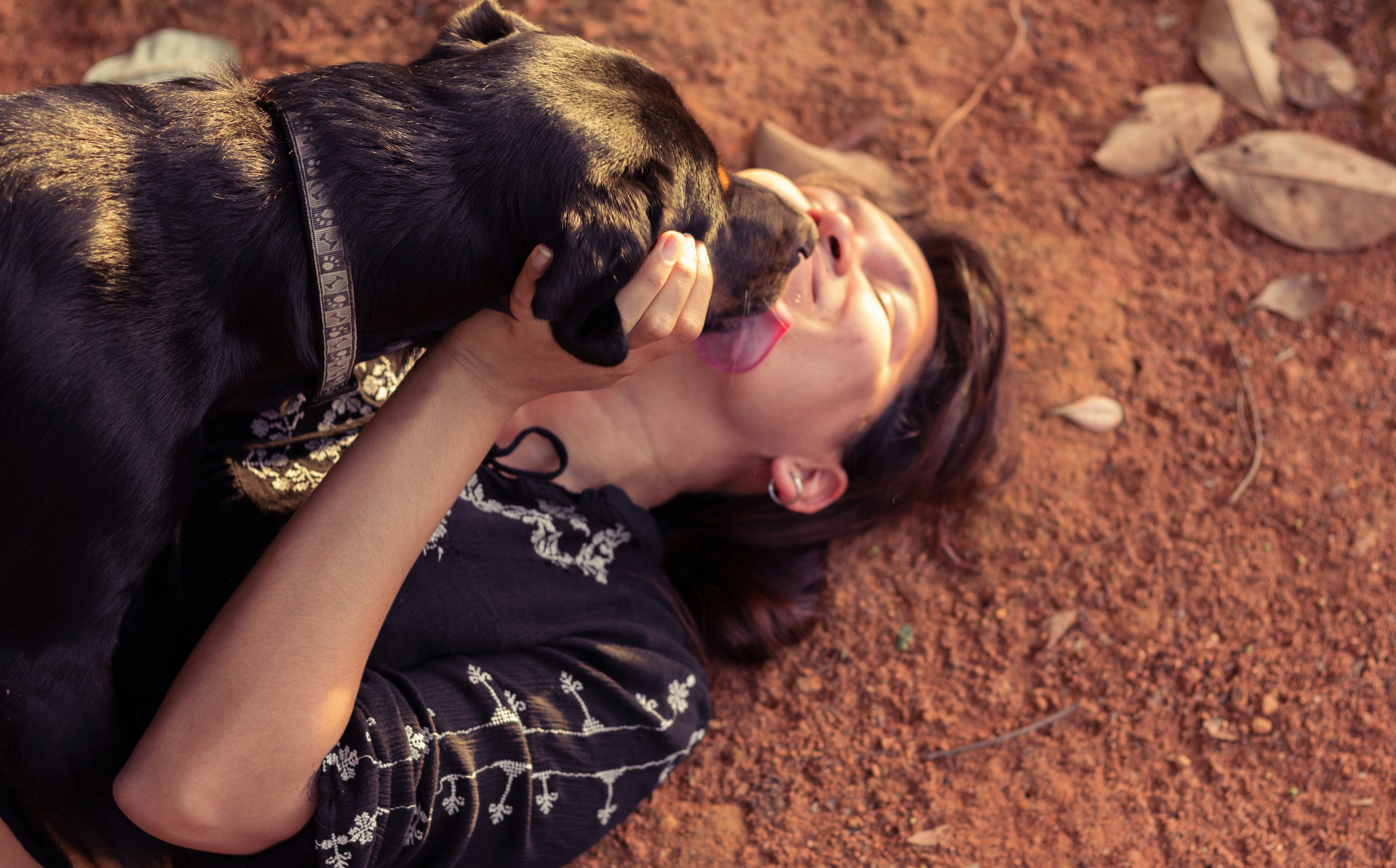 woman in black and white floral dress lying on brown ground with black and brown short