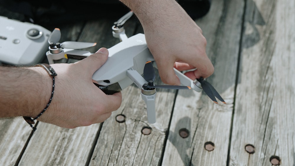 person holding white and silver hand tool