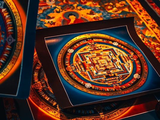 A collection of intricate, colorful mandala artworks, featuring symmetrical geometric patterns with vibrant hues of red, blue, and gold. Each piece displays a complex design, evoking a sense of spiritual and artistic expression.