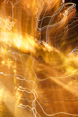 Abstract golden light trails moving over a charcoal black background.