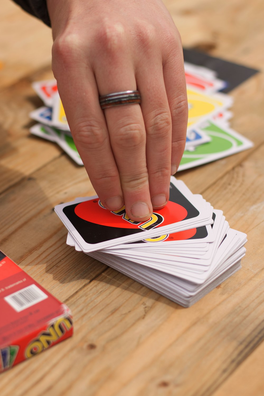 person wearing silver ring holding white and red book