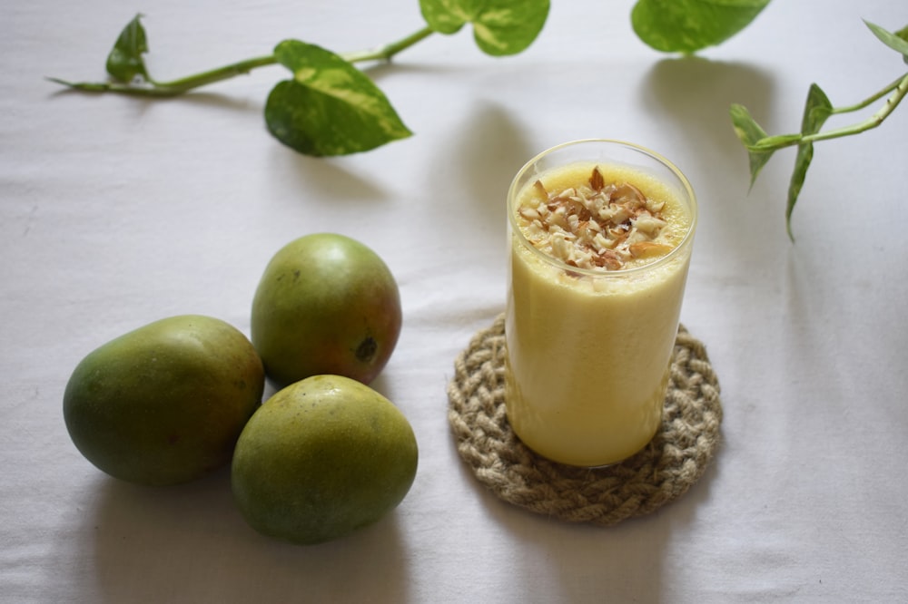 Grüner Apfel neben klarem Trinkglas mit Milch