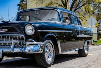 black classic car on gray concrete pavement