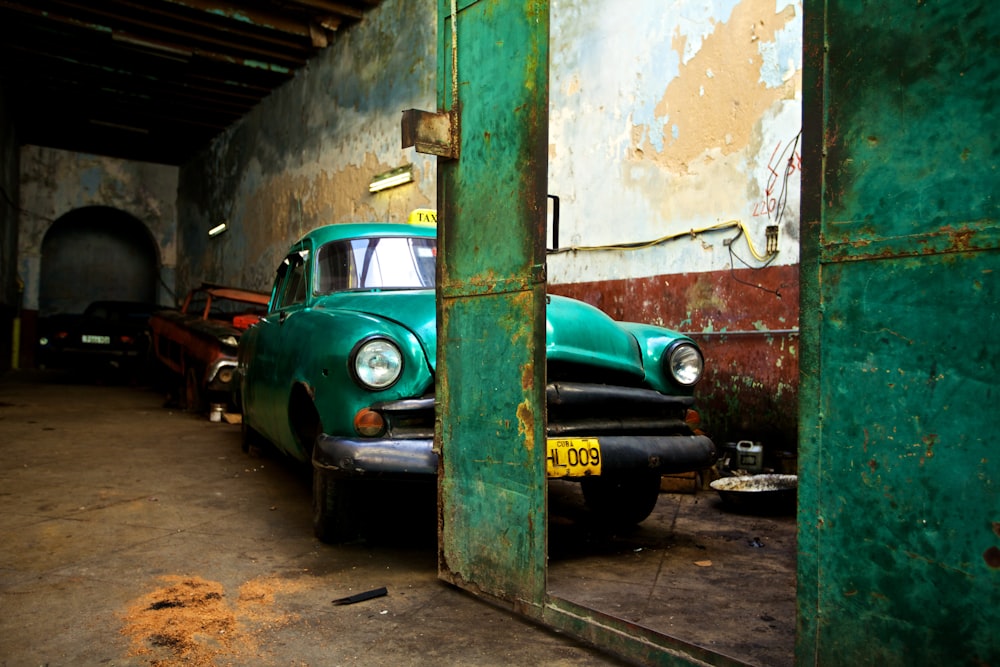 green car parked beside green and white wall