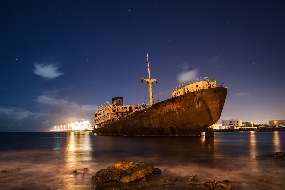 brown ship on sea during night time