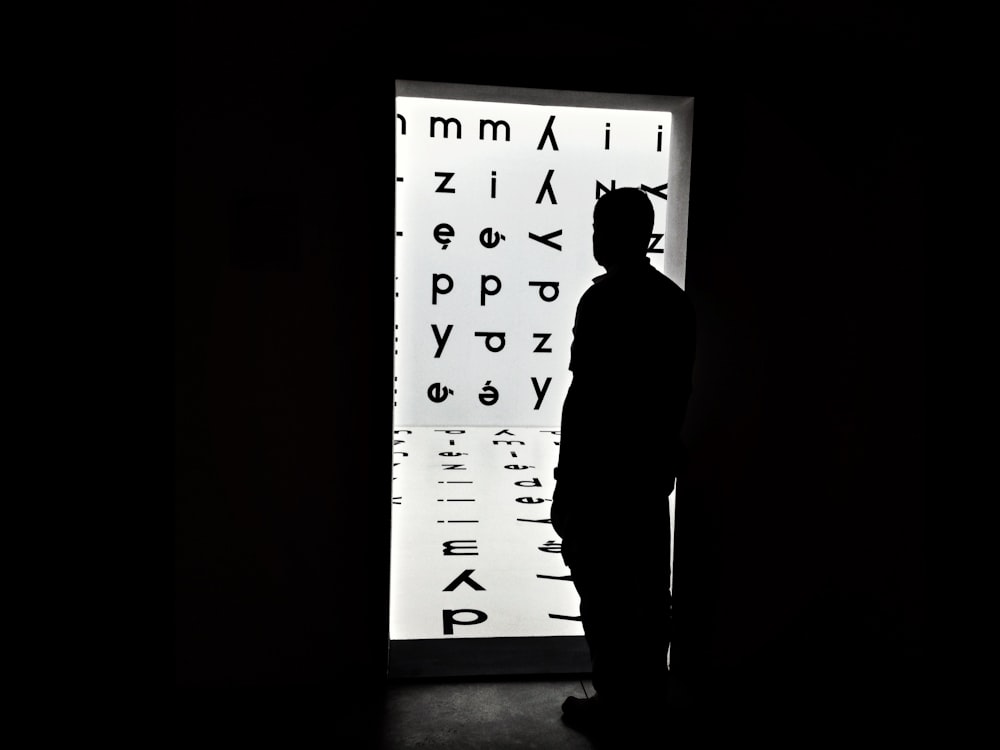 silhouette of man standing in front of white and black wall