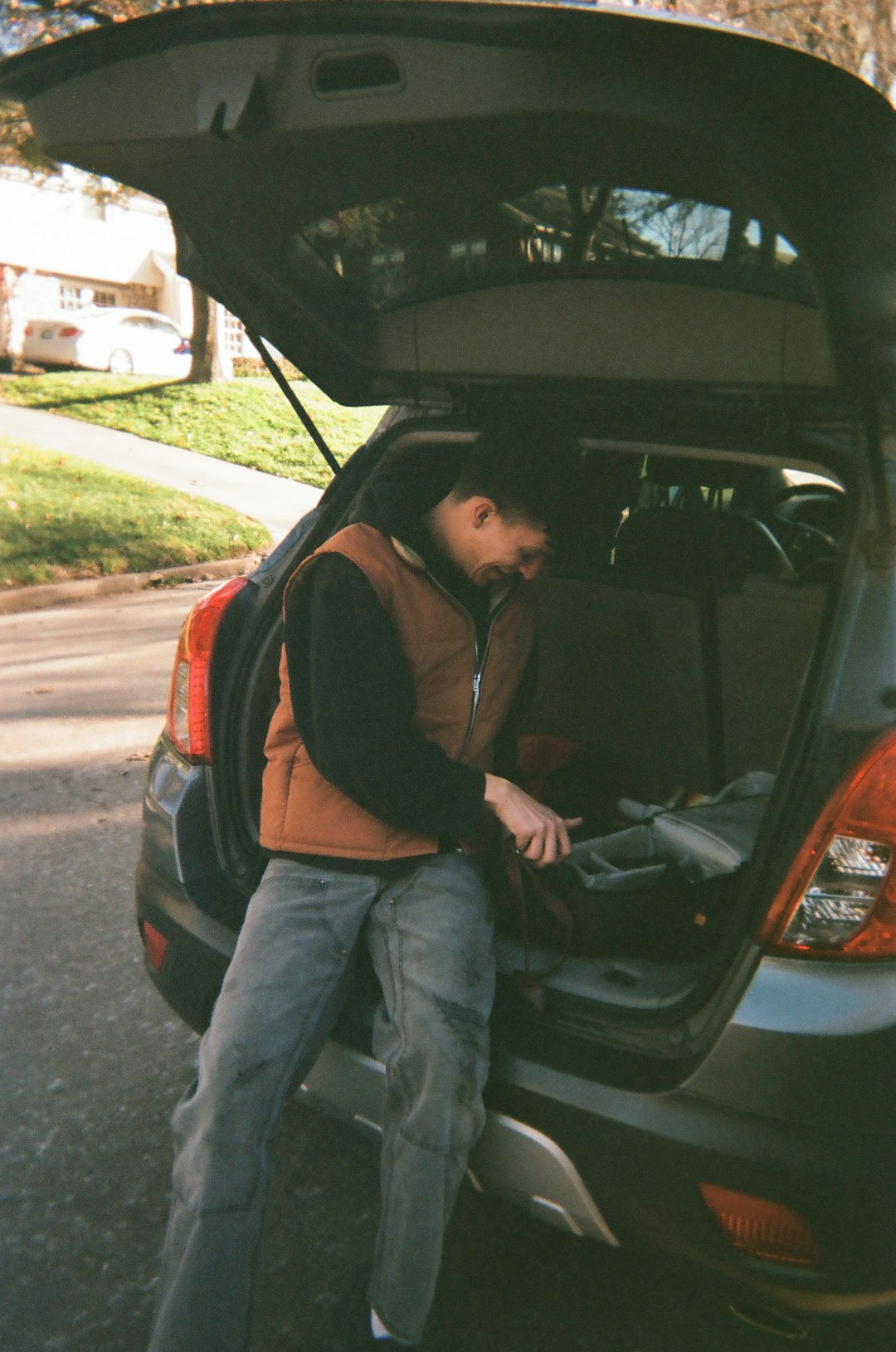 man in black jacket sitting on black car