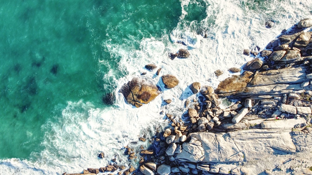 brown rocky shore with water waves during daytime