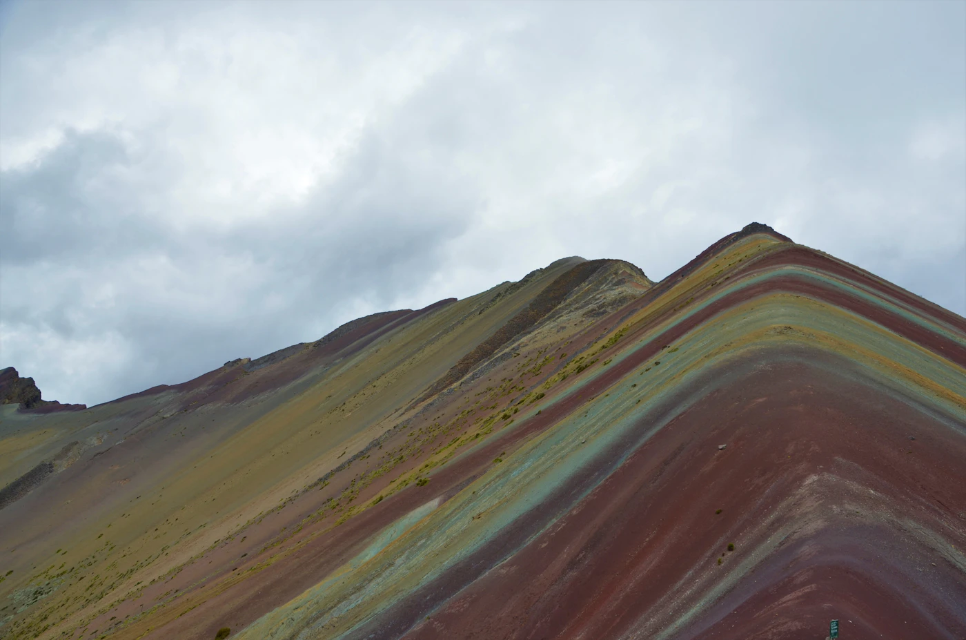 Montaña de tonos marrones y verdes bajo nubes blancas