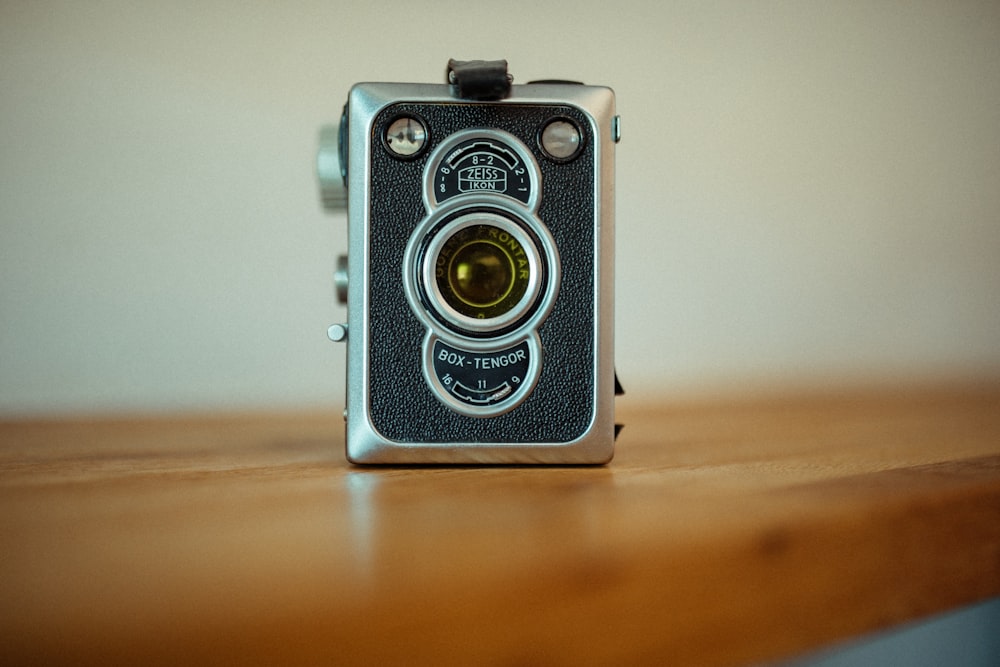 gray and black camera on brown wooden table