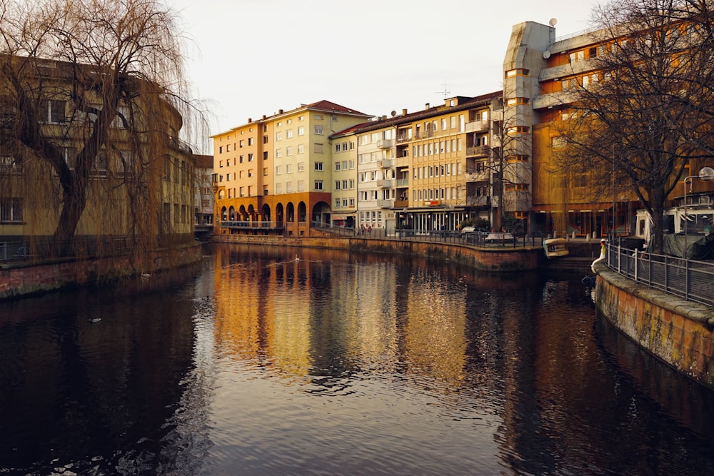 brown concrete building beside river during daytime