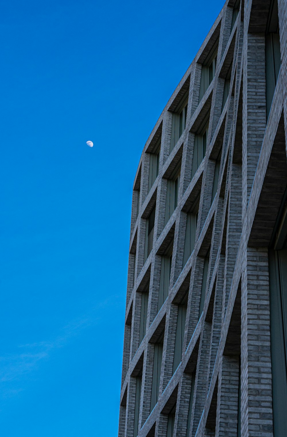 Bâtiment en béton noir sous un ciel bleu pendant la journée