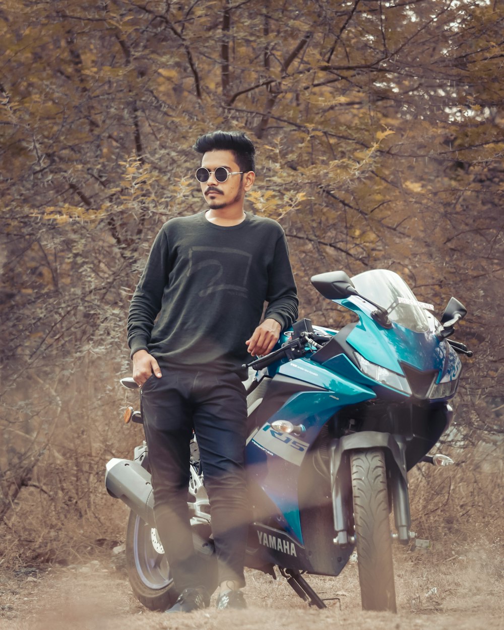 man in black sweater riding blue and white honda motorcycle