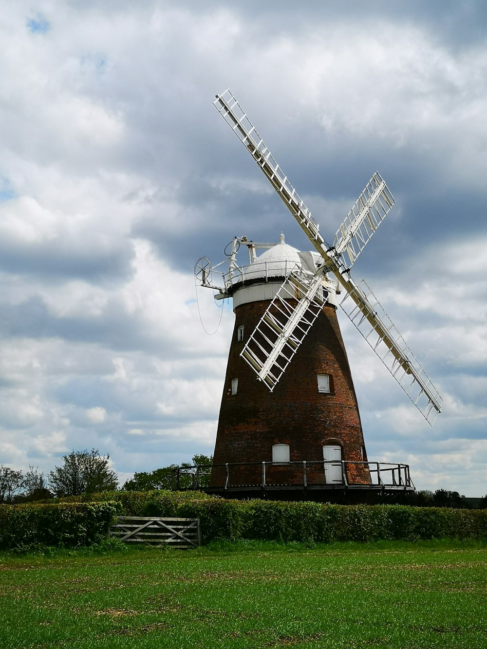 brown and white windmill under cloudy sky during daytime