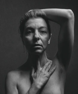 topless woman with left hand on head